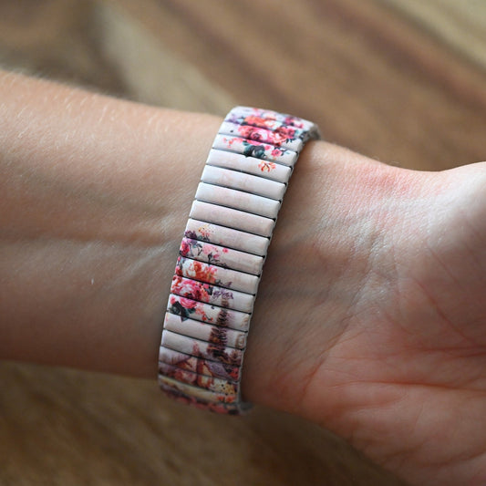 Elastisches Armband mit Shabby-Rose-Muster auf weißem Grund, getragen am Handgelenk einer Person