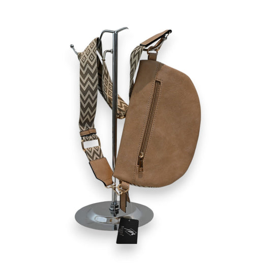 Beige Gürteltasche mit Chevron-Muster, Boho-Stil, auf Metallständer. Breiter Gurt und Reißverschluss sichtbar.