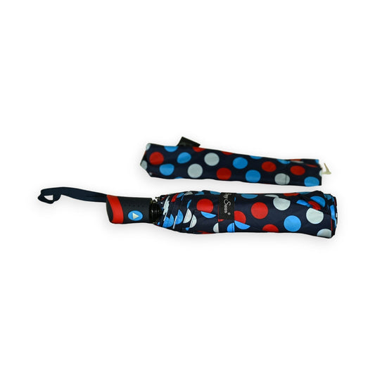 Halbautomatischer Taschenschirm mit Punktemuster in Rot, Blau und Weiß auf dunklem Hintergrund, zusammengefaltet