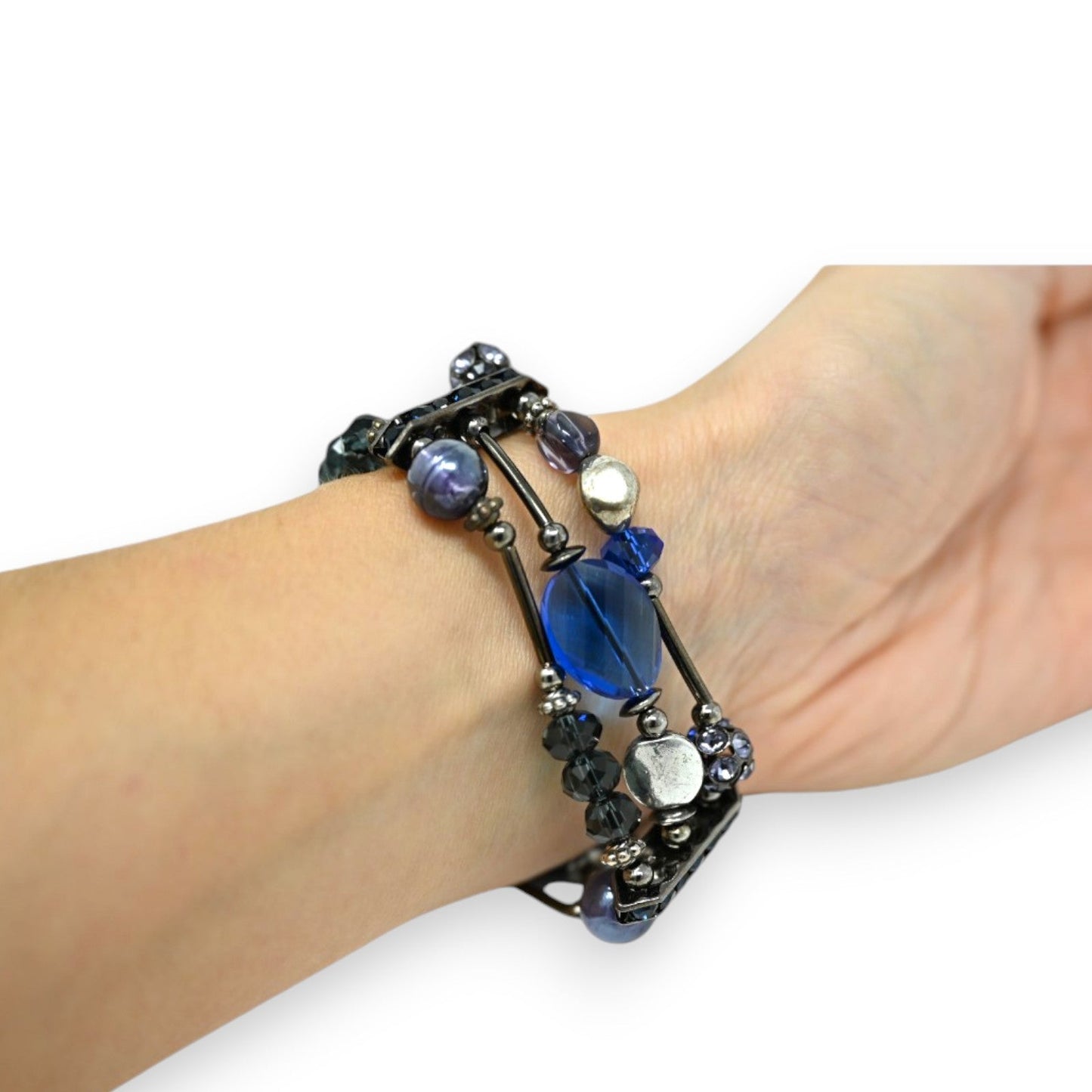 Dreireihiges Armband mit blauen und silbernen Perlen auf Metalldraht, am Handgelenk getragen