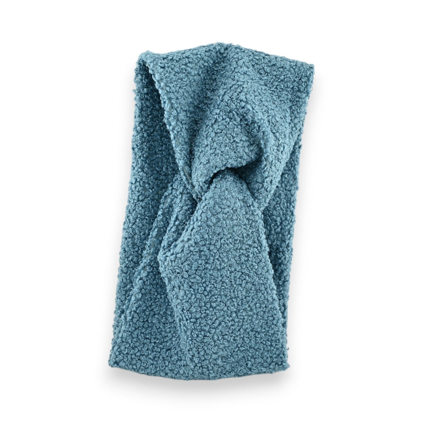 Blaues Bouclé-Stirnband aus Jeansstoff, gefaltet auf weißem Hintergrund. Kuschelige Winteraccessoire mit flauschiger Textur.