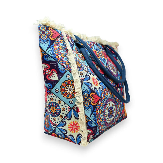 Bunte Nylon-Tragetasche mit geometrischem Muster, Fransen und blauen Henkeln, ideal für Strand oder Einkauf