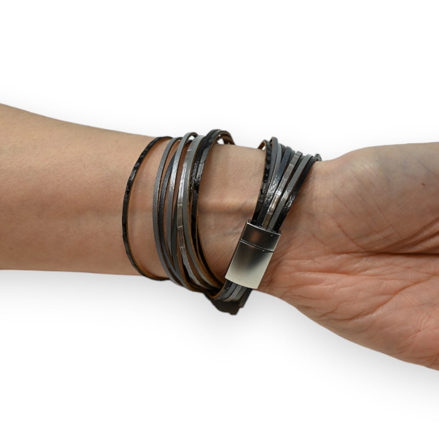 Mehrfach gewickeltes Lederarmband in Grau- und Schwarztönen mit Metallverschluss am Handgelenk getragen
