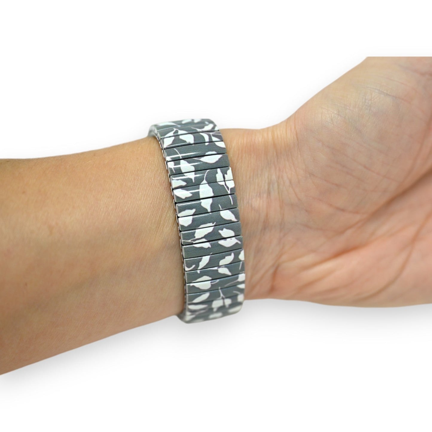 Elastisches Armband mit grau-weißem Blättermuster auf Handgelenk, modischer Schmuck im Camouflage-Look