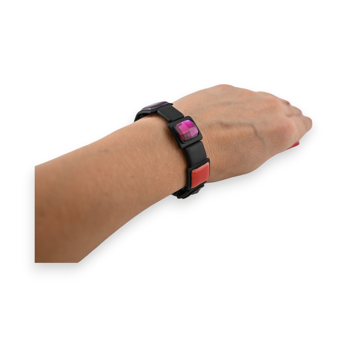 Elastisches Armband mit bunten quadratischen Elementen auf Handgelenk, modernes Design in Schwarz, Pink und Rot