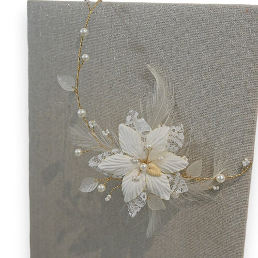 Elegante Elfenbein-Halskette mit Blumendesign, Perlen und Federn auf grauem Hintergrund. Filigrane Hochzeitsschmuck-Dekora...