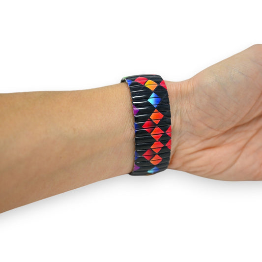 Buntes Armband mit geometrischem Muster aus schwarzen und farbigen Dreiecken auf einem Handgelenk