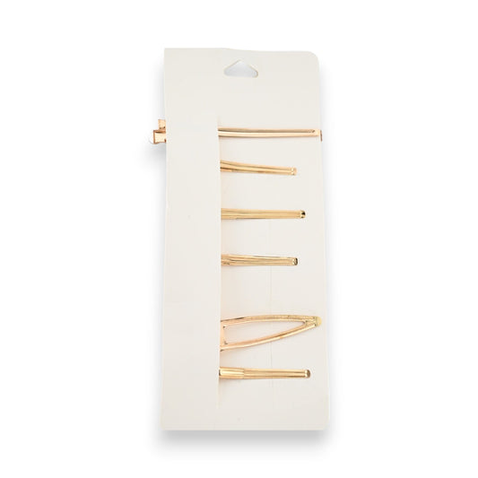 Set goldene Haarspangen auf weißem Karton, verschiedene Formen und Größen, minimalistisches Design