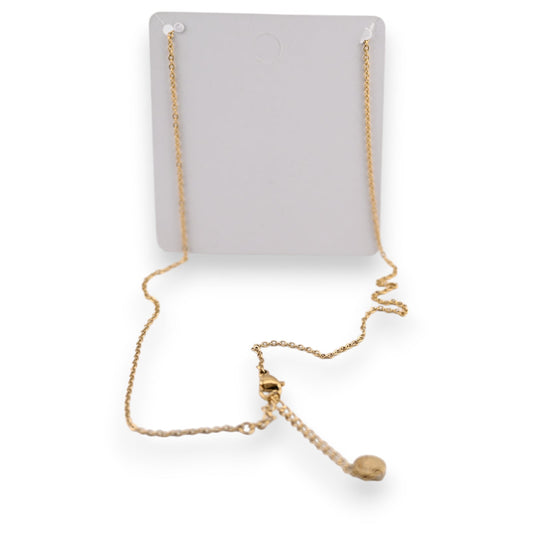 Goldene Halskette mit feiner Kette und kleinem Anhänger auf grauem Schmuckdisplay, elegantes Accessoire
