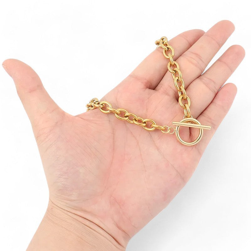 Goldene Stahlkette mit Medaillon-Verschluss auf offener Handfläche, Schmuck-Nahaufnahme für Online-Shop