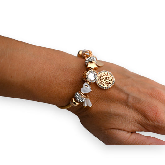 Goldenes Charm-Armband mit Baum des Lebens Anhänger, Herzen und Kristallen auf Handgelenk einer Frau