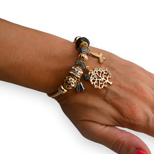 Goldenes Charm-Armband mit Lebensbaum-Anhänger, Perlen und Kristallen auf brauner Haut, eleganter Schmuck