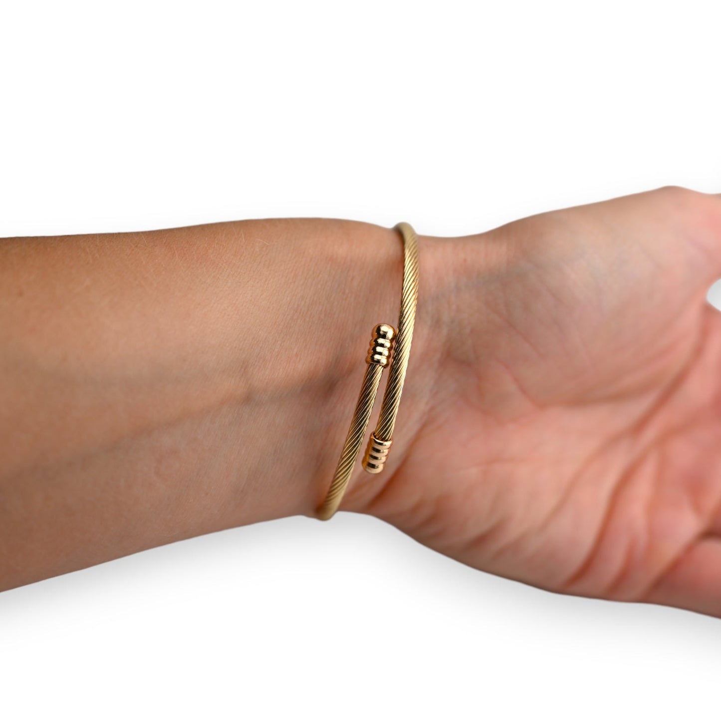 Goldenes Armreif mit geriffeltem Design auf Handgelenk, flexibel und elegant, mit dekorativen Endstücken