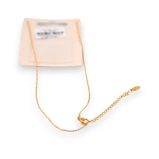 Feines goldenes Stahlhalsband mit Anhänger auf cremefarbener Verpackung, elegantes Schmuckstück für Damen