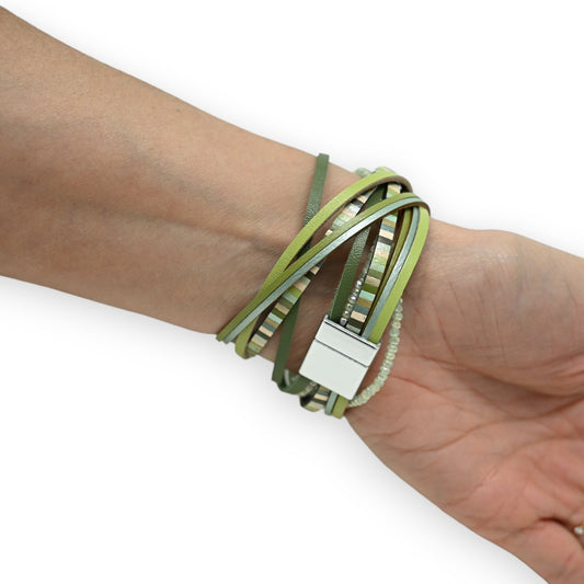 Grünes Lederarmband mit mehreren Wicklungen, Perlen und silbernem Verschluss am Handgelenk einer Person
