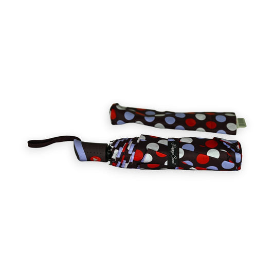 Halbautomatischer Klappschirm mit Punktemuster in Rot, Blau und Weiß auf schwarzem Grund, zusammengefaltet