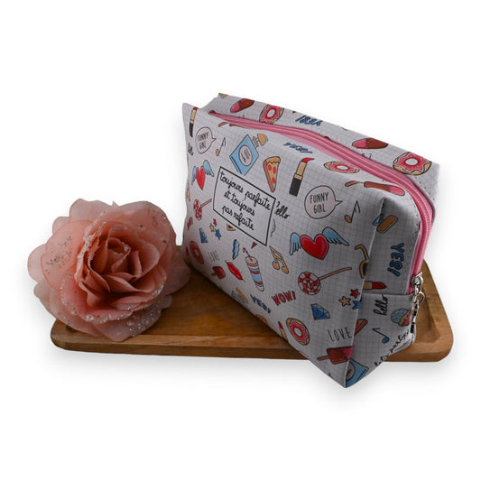 Kinder Kosmetikkoffer mit buntem Muster, rosa Reißverschluss und rosa Blume auf Holzuntergrund, Mädchen-Accessoire