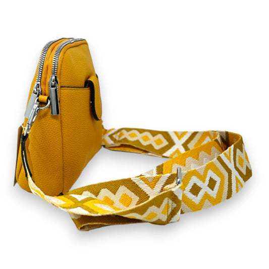 Kompakte senfgelbe Umhängetasche mit geometrischem Muster-Gurt, Reißverschluss und Lederoptik auf weißem Hintergrund