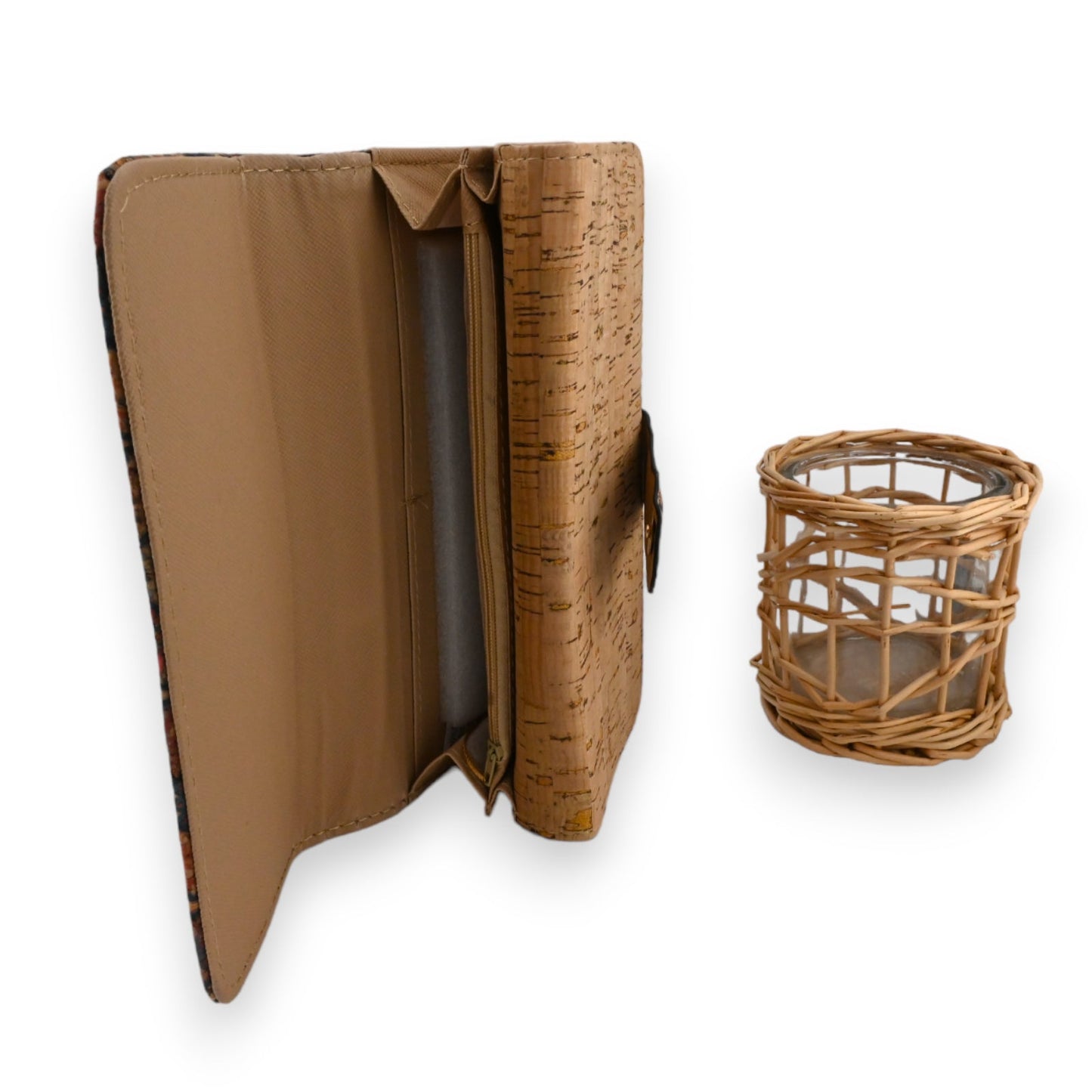 Geometrische Kork-Geldbörse geöffnet, zeigt Innendetails, neben geflochtenem Weidenkorb mit Glaseinsatz auf weißem Hinterg...