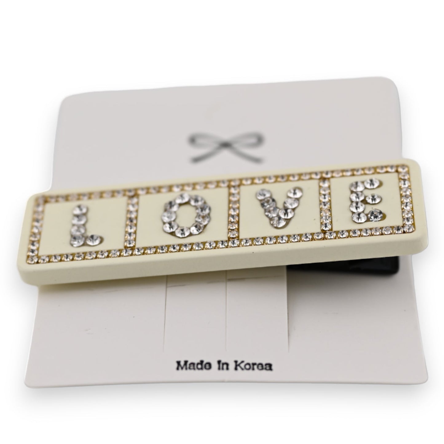 Elegante Haarspange mit 'LOVE' Schriftzug aus Strass-Steinen auf cremefarbenem Grund, Made in Korea