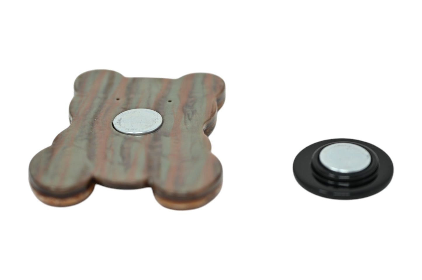 Magnetische Brosche in Teddybärform aus marmoriertem Kunstharz und separater schwarzer Magnethalter auf weißem Hintergrund