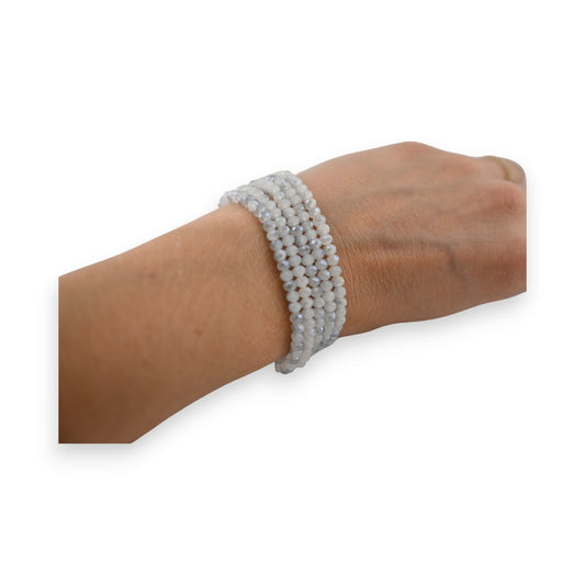 Mehrreihiges Armband mit glänzenden grauen Perlen an einem Handgelenk, eleganter Modeschmuck für Damen