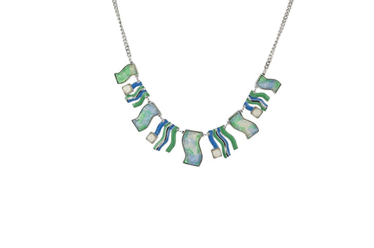 Elegante Halskette mit blau-grünen Elementen, wellenförmigen Mustern und opalartigen Steinen an silberner Kette