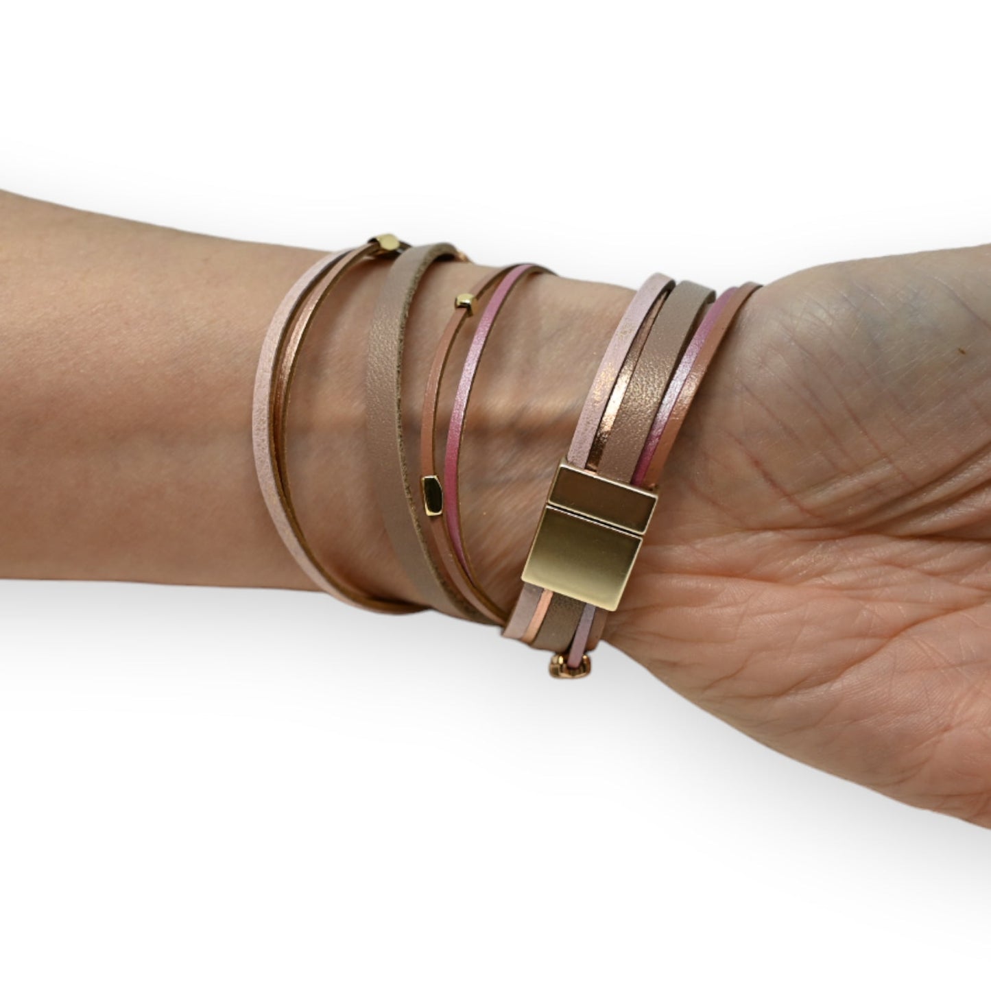 Mehrfaches Lederarmband in Rosatönen mit goldfarbenen Akzenten und Verschluss, am Handgelenk getragen