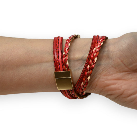 Rotes geflochtenes Lederarmband mit goldenem Verschluss, doppelt um Handgelenk gewickelt, auf Haut präsentiert