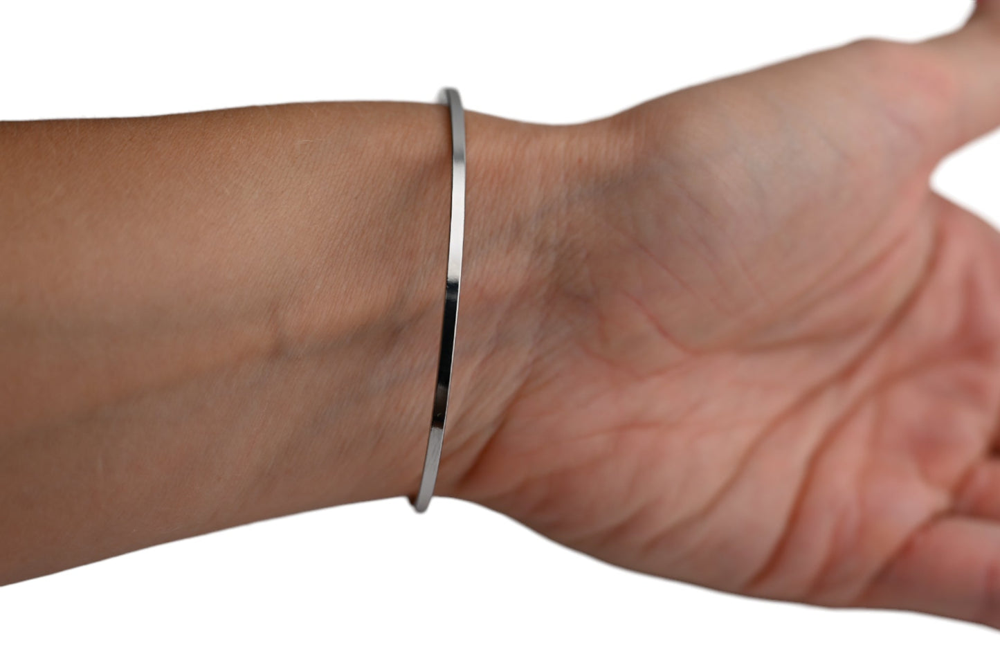 Schlankes silbernes Armband am Handgelenk, minimalistisches Design, glänzende Oberfläche, eleganter Schmuck