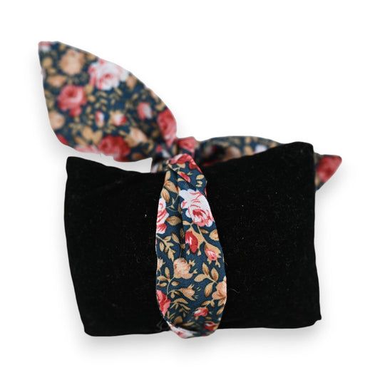 Schwarzes Samtkissen mit floraler Stoffschleife, Vintage-Blumenmuster in Blau, Rosa und Beige auf dunkelblauem Grund