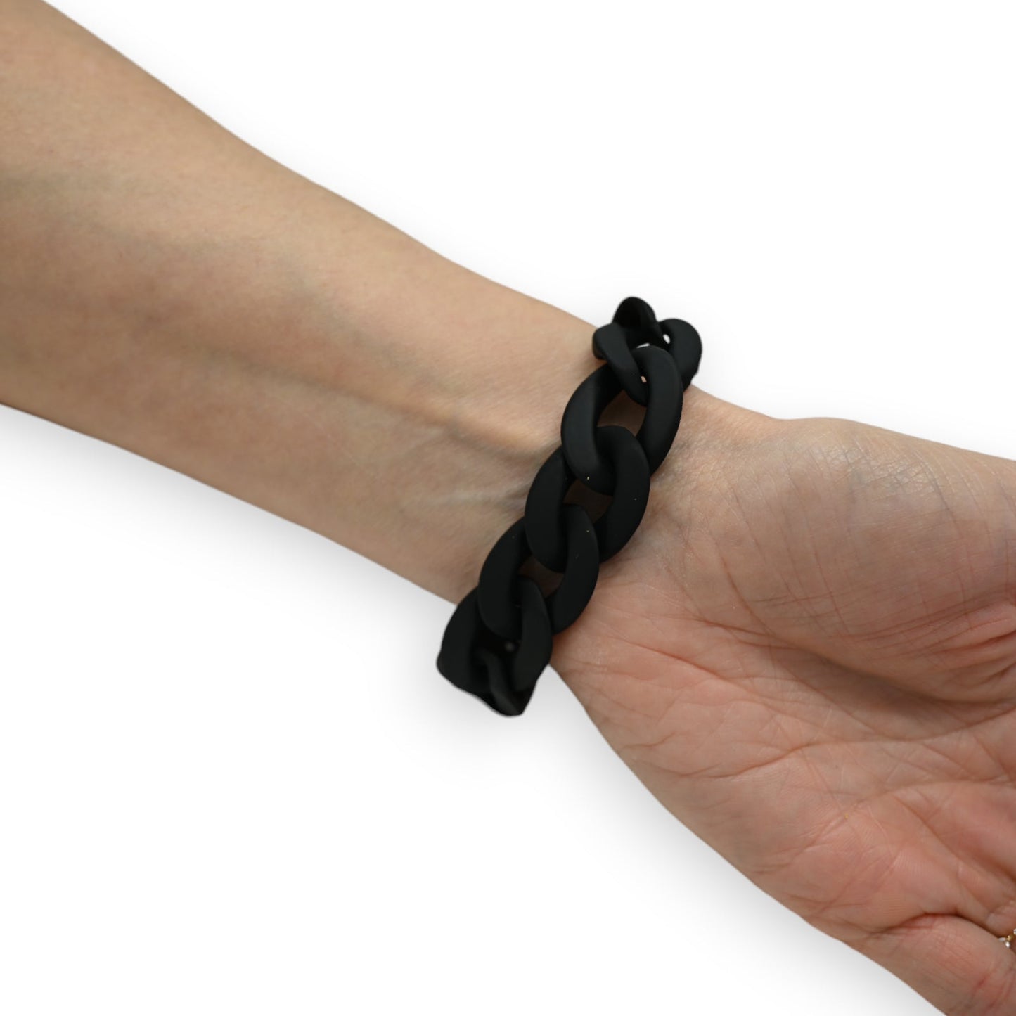 Schwarzes Silikonarmband mit großen Kettengliedern am Handgelenk einer Person auf weißem Hintergrund
