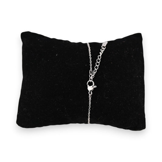 Silberfarbenes Stahlarmband auf schwarzem Samtkissen, feine Kette mit Verschluss sichtbar, elegantes Schmuckstück