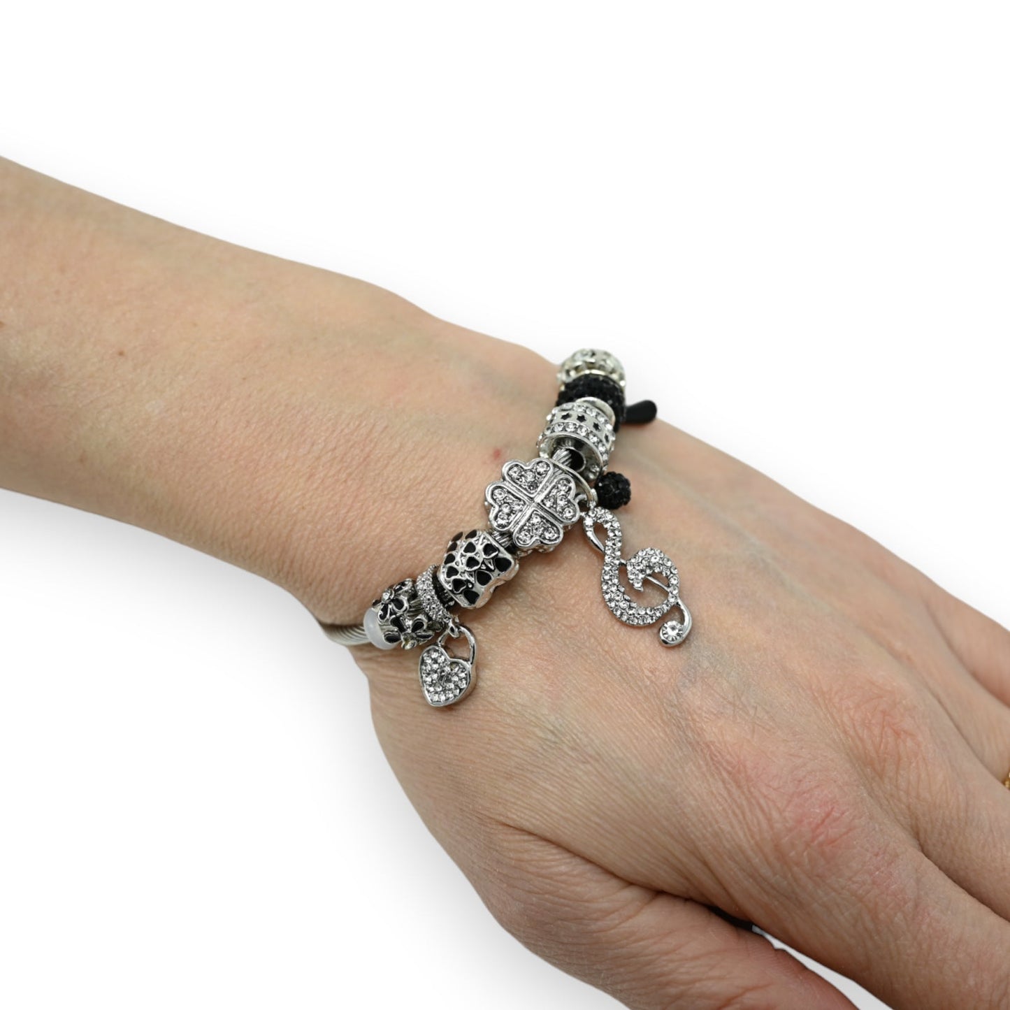 Silber-Schwarz Charm-Armband mit Perlen, Kleeblatt und Schlüsselnote-Anhänger auf Handgelenk, Schmuck-Accessoire