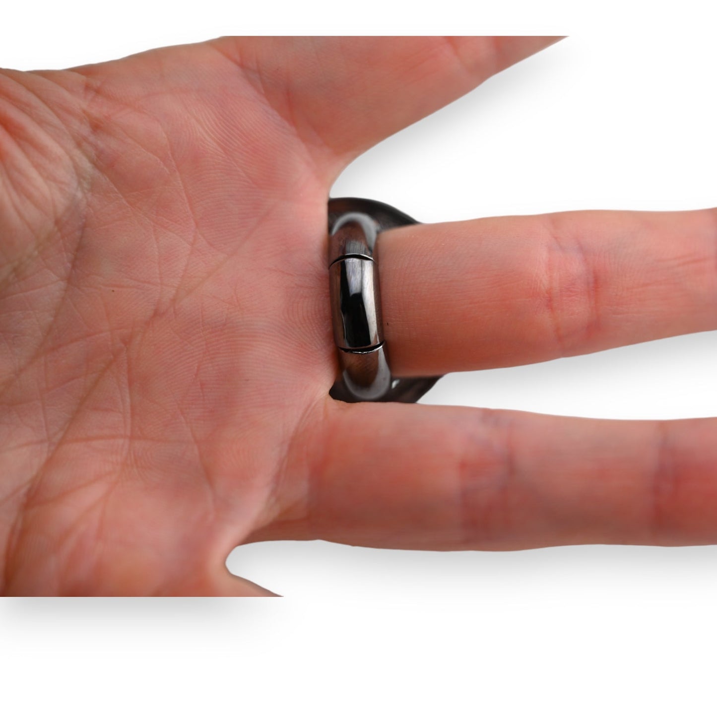 Silbergrauer Fantasie-Ring mit Herzmotiv auf einer Hand, Nahaufnahme zeigt glänzende Oberfläche und moderne Form