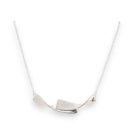 Elegante silberne Halskette mit geschwungenem Anhänger, strukturiertes Design, moderner Schmuck auf weißem Hintergrund