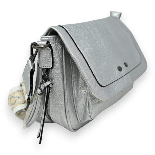 Silberne Leder-Umhängetasche mit Reißverschluss, Klappe und dekorativem Stoffriemen, seitliche Ansicht auf weißem Hintergrund