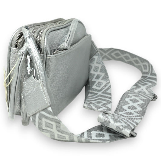 Silberne quadratische Umhängetasche mit mehreren Reißverschlusstaschen und geometrisch gemustertem Schulterriemen