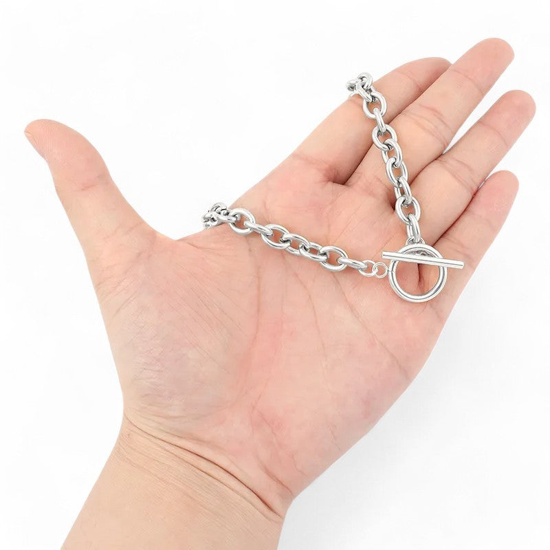Silberne Stahlkette mit rundem Verschluss auf offener Handfläche, Schmuck-Armband mit Gliederdesign
