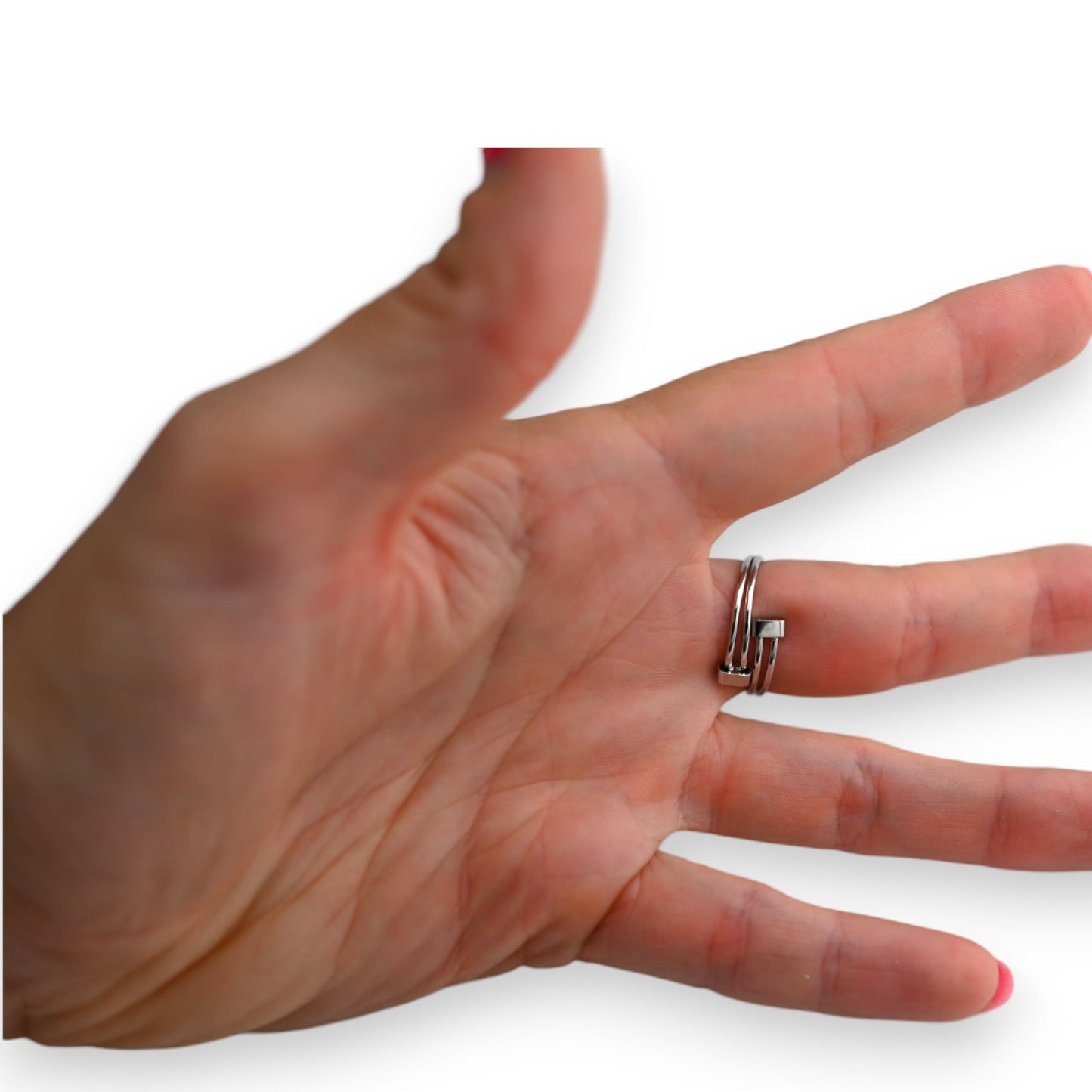 Silberner Ring mit Knotendesign auf einem Finger einer ausgestreckten Hand vor weißem Hintergrund