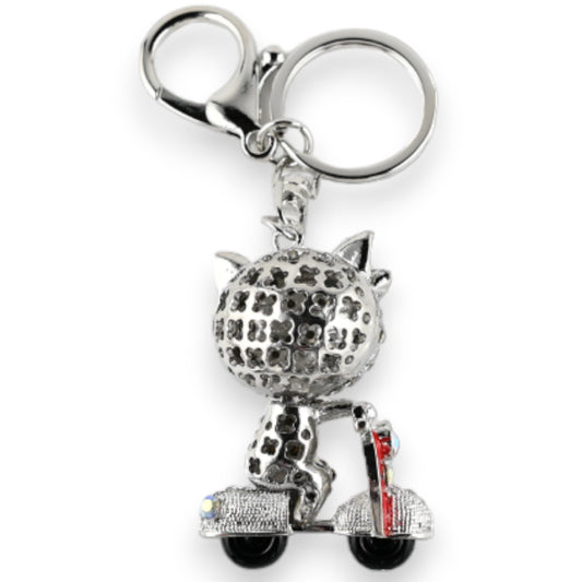 Silberner Schlüsselanhänger mit Katze auf Roller. Figur aus Metall mit Musterung, sitzend auf detailliertem Motorroller.