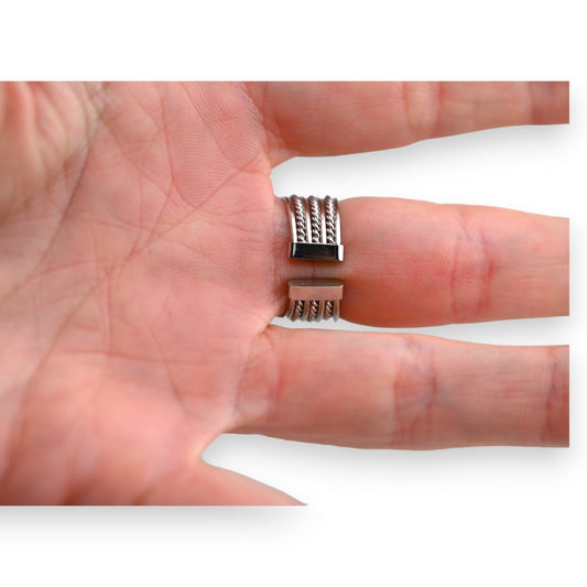 Silberner Sonnenring mit drei gedrehten Stahlbändern, auf der Handfläche präsentiert, offene Form