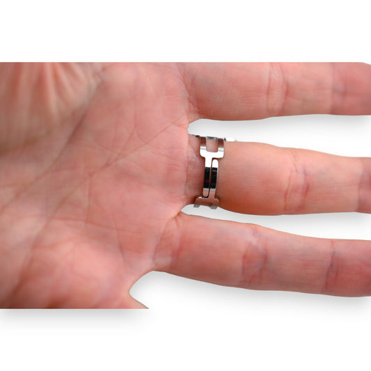 Silberner Stahlring mit ovaler geometrischer Form an einem Finger, Nahaufnahme der Hand und des Rings