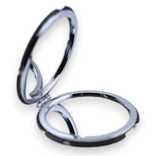 Aufgeklappter runder Taschenspiegel mit silbernem Rahmen auf weißem Hintergrund, geöffnet und reflektierend