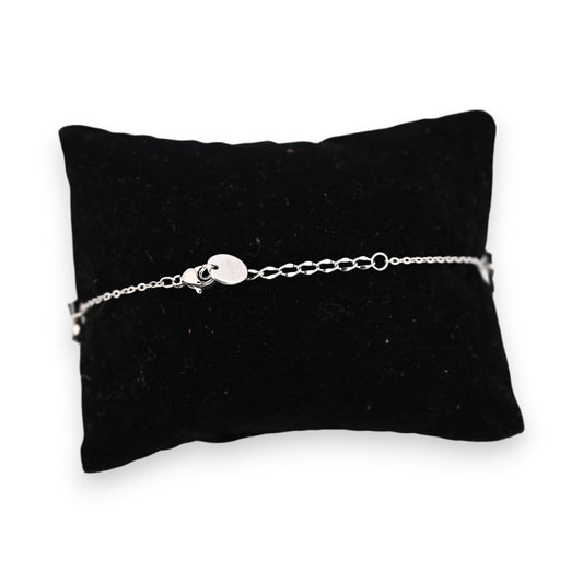 Feines silberfarbenes Stahlarmband mit Kettenverschluss auf schwarzem Samtkissen, elegantes Schmuckstück