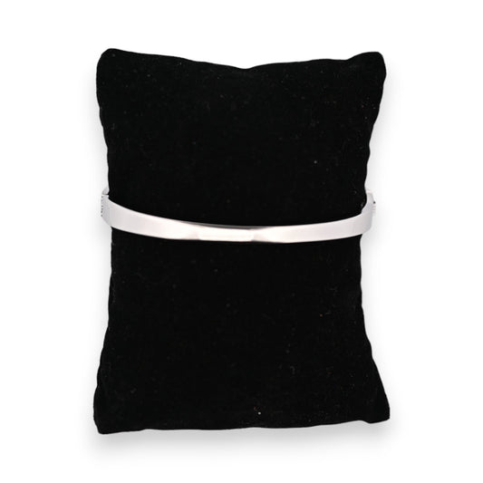 Schwarzes Schmuckkissen mit silberfarbenem Stahlarmband LOVE darauf präsentiert, minimalistisches Design