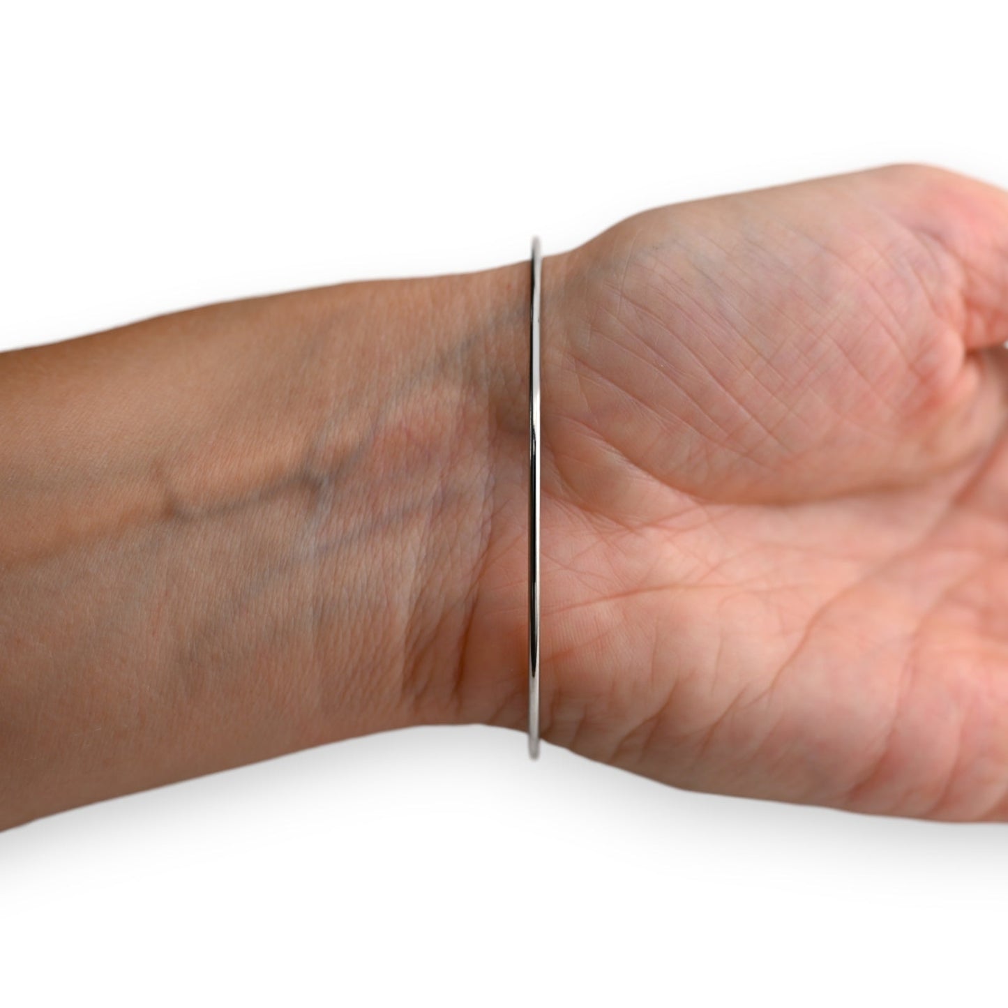 Schlankes silbernes Armband an einem Handgelenk, minimalistisches Design, eleganter Schmuck für Damen