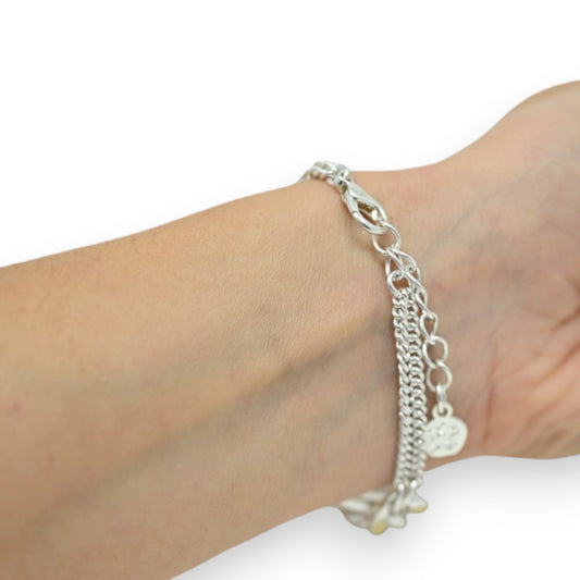 Silbernes Armband mit mehreren Ketten und Anhängern, getragen am Handgelenk einer Person mit heller Haut