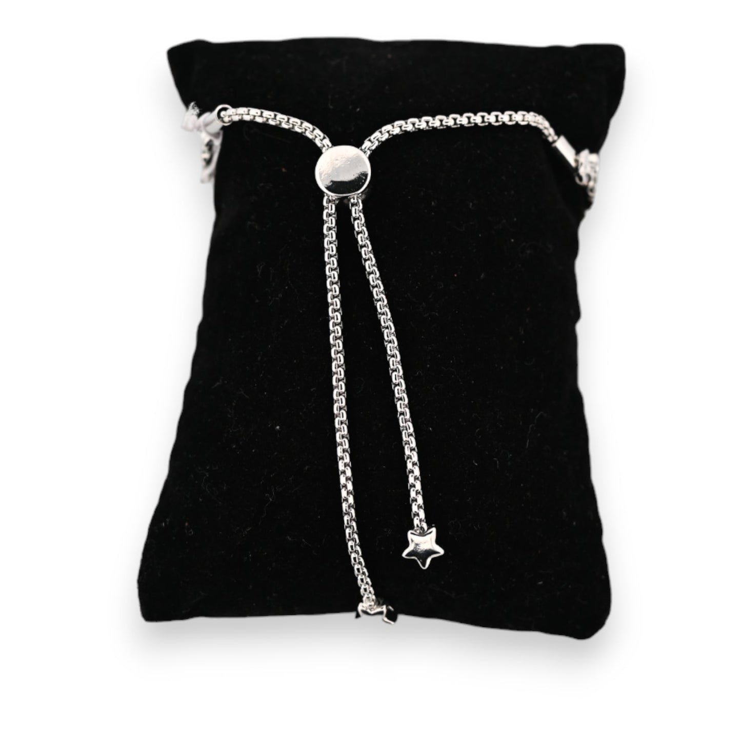 Silbernes Stahlarmband auf schwarzem Samtkissen, verstellbar mit glänzendem Schiebeverschluss und hängenden Sternanhängern