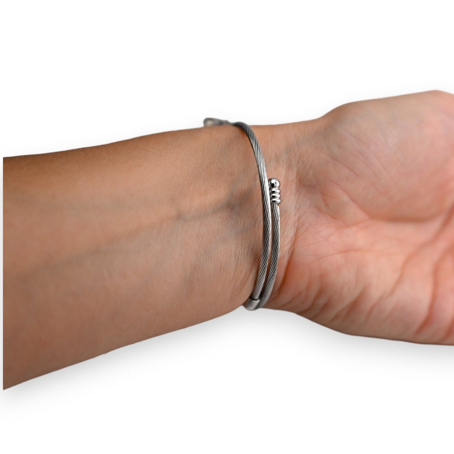 Silberfarbenes Armband aus feinem Drahtgeflecht mit kleiner Spiralverzierung, am Handgelenk getragen